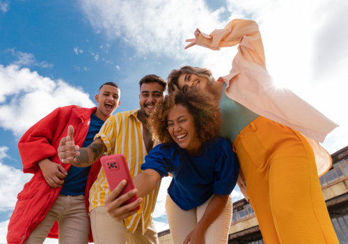 Photo of a group of teenagers posing while one takes a selfie