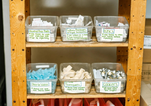 Photo of 2 shelves holding 3 containers of supplies on each shelf