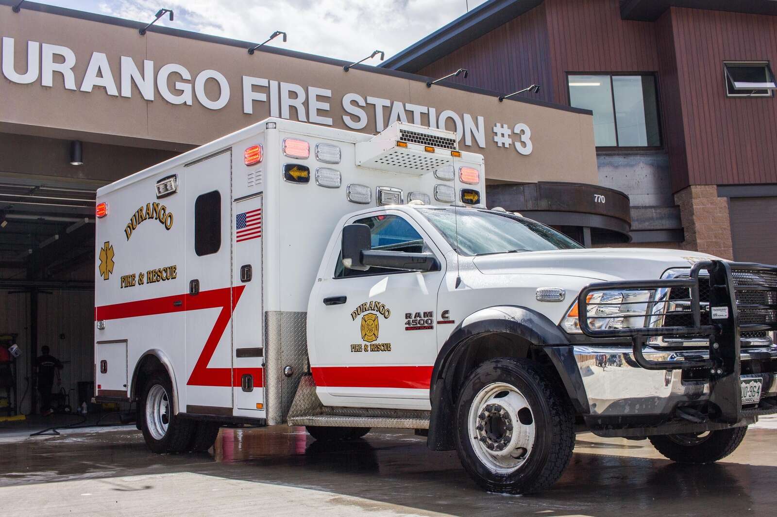 Photo of a Durango ambulance with white chassis and red, Z-stripe parked in front of Durango Fire Station #3