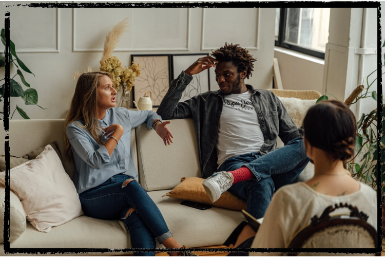 Photo of a white woman and Black man sitting on a sofa and a therapist sitting across from them