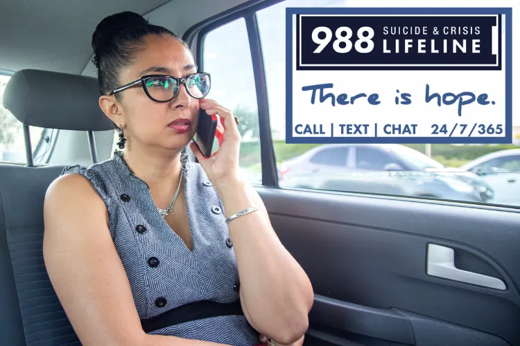 Photo of Latina woman wearing glasses and hair in a bun talking on her cell phone while sitting in her car