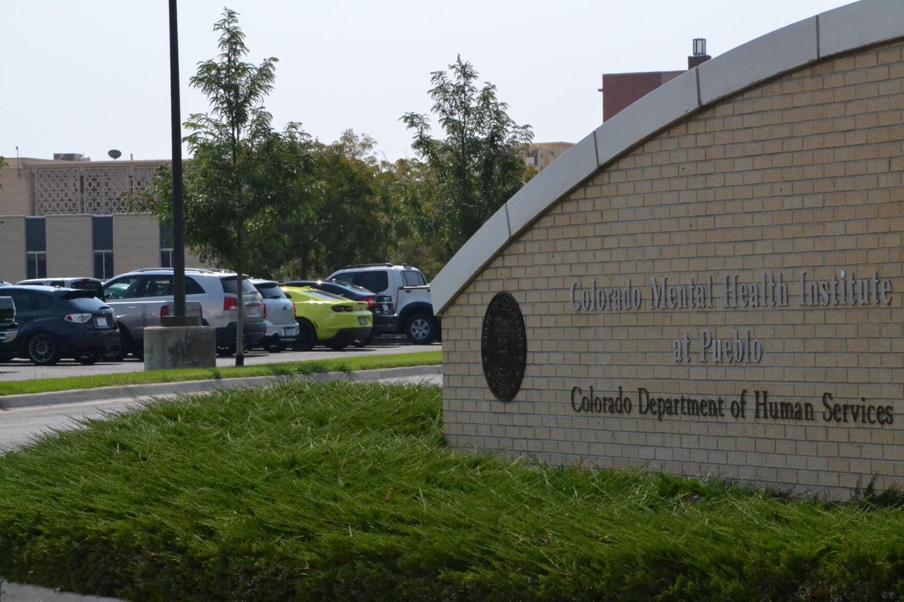 Photo of a rounded, blond brick wall with the words Colorado Mental Health Institute in Pueblo