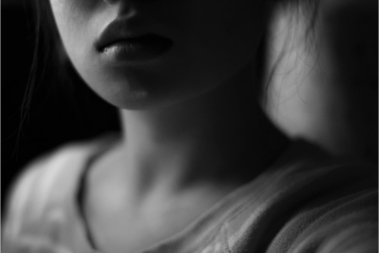B&W, hazy photo of the lower half of a young woman's face and neck
