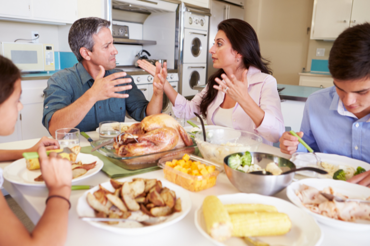 A family sits at the dinner table. A man and woman argue.