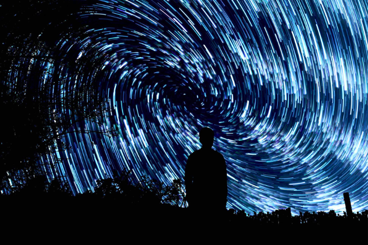 Composite photo of swirling stars astro-photograph and photo of a boy looking up