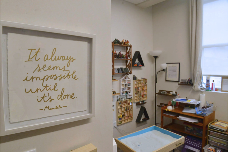 Photo of a room with a framed quote, toys, paper and pens, a lamp and a shaded wind