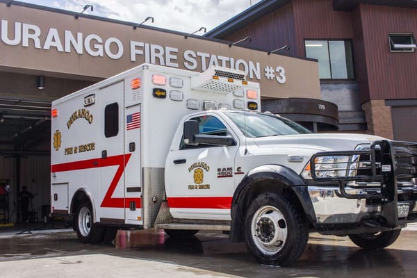 Photo of a Durango ambulance with white chassis and red, Z-stripe parked in front of Durango Fire Station #3