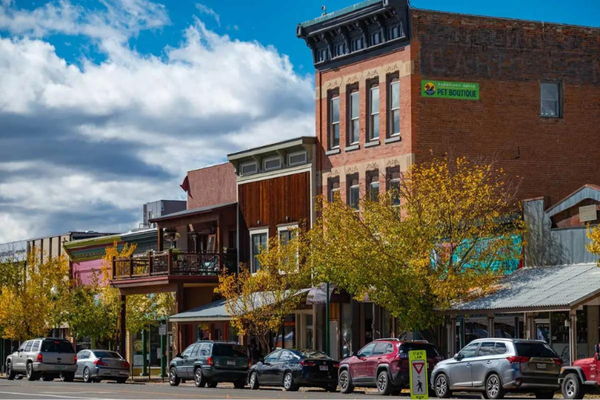 Photo of a main street with Victorian, red brick buildings, cars on the street
