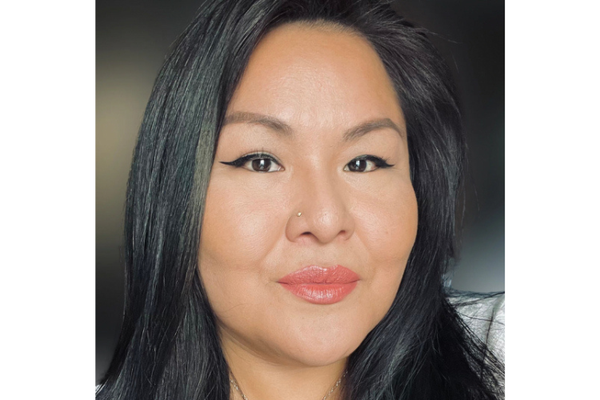 An Indigenous woman with long, black hair and a confident gaze.